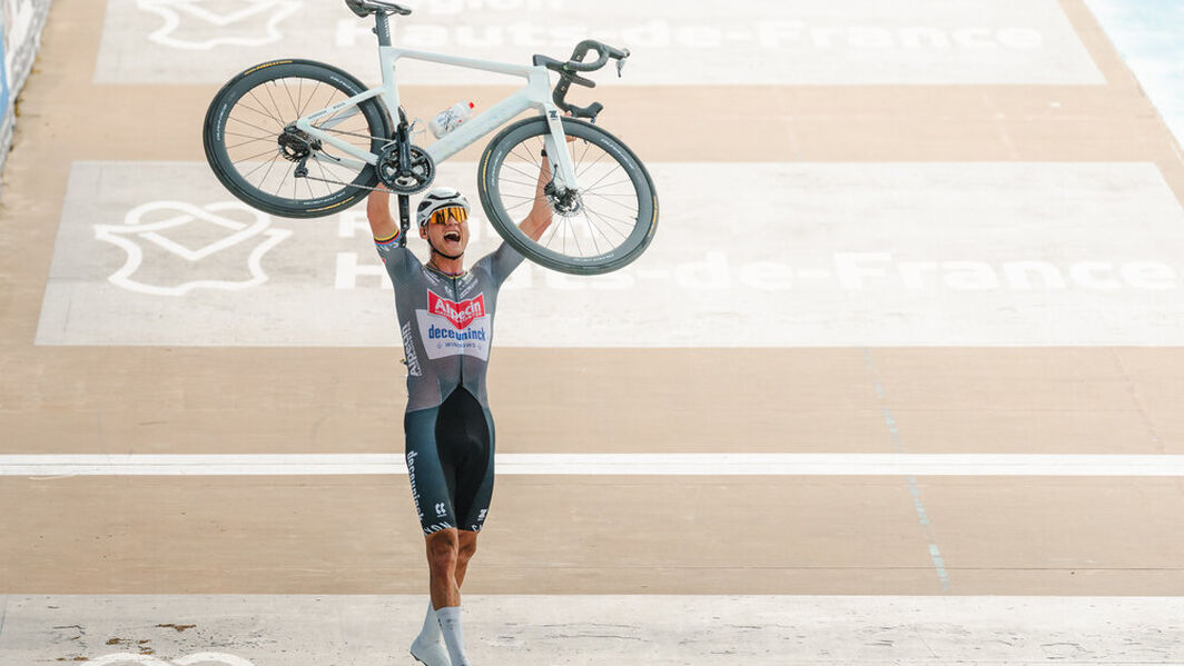 Mathieu van der Poel raises his Aeroad CFR Tensor to the sky after winning his third Paris-Roubaix in a row. The special edition model sports a design inspired by the brutal impact of the Roubaix cobblestones.