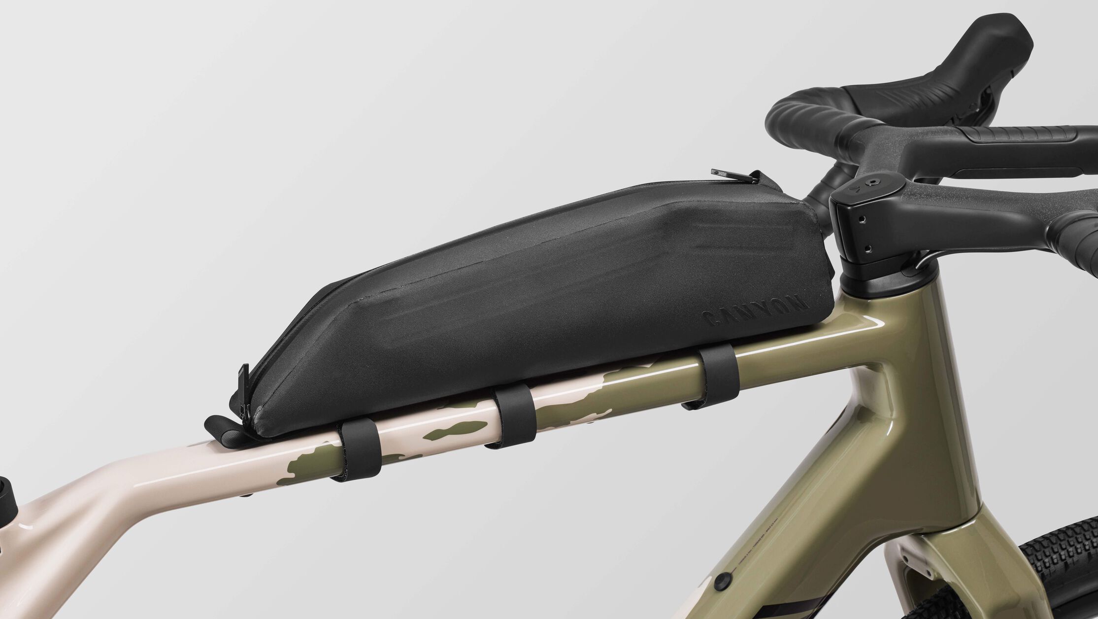Close-up of a Canyon Grizl CF 7 ESC gravel bike showing a mounted top tube bag, ideal for beginners carrying snacks, tools, or gear on longer rides.