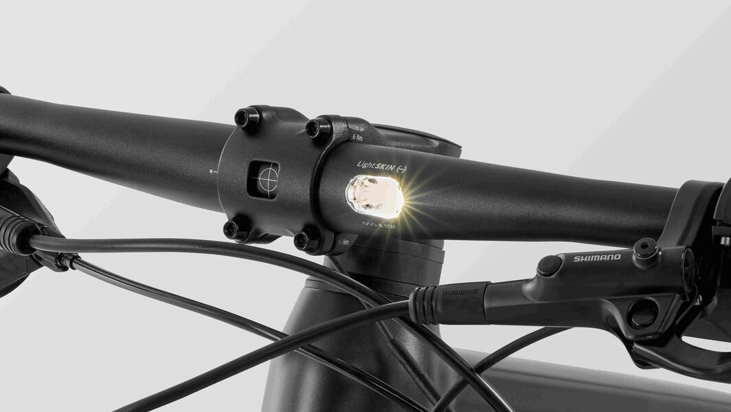 Close-up of Canyon Roadlite:ON handlebar showing integrated front light and Shimano brake system